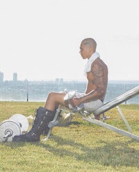 a man sitting on a bench in a park with a view of the city