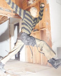 a man in a striped sweater jumping in a room