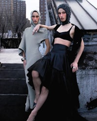two women posing on a rooftop