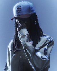 a man with dreadlocks and a baseball cap